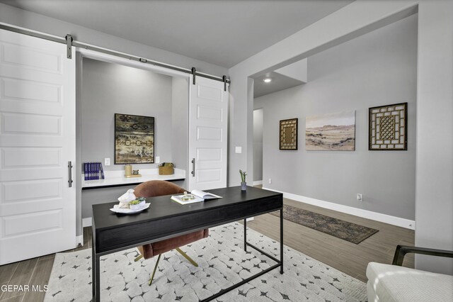 office featuring hardwood / wood-style flooring and a barn door