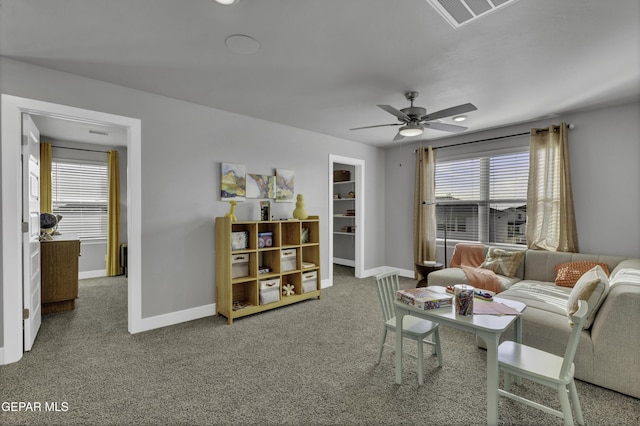 living room with ceiling fan, carpet floors, and a wealth of natural light