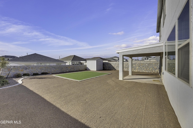 view of yard featuring a patio and a storage unit