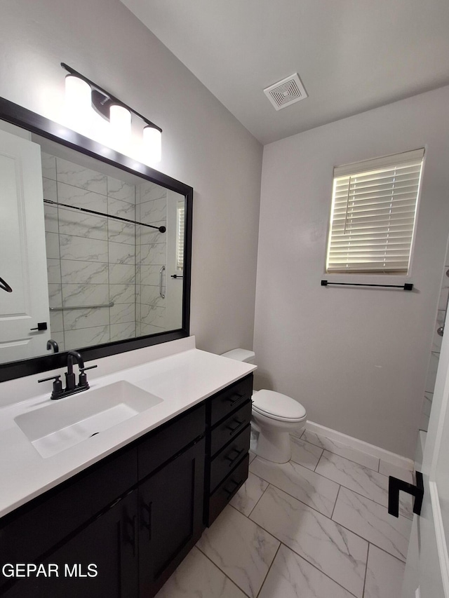 bathroom featuring vanity, toilet, and a shower