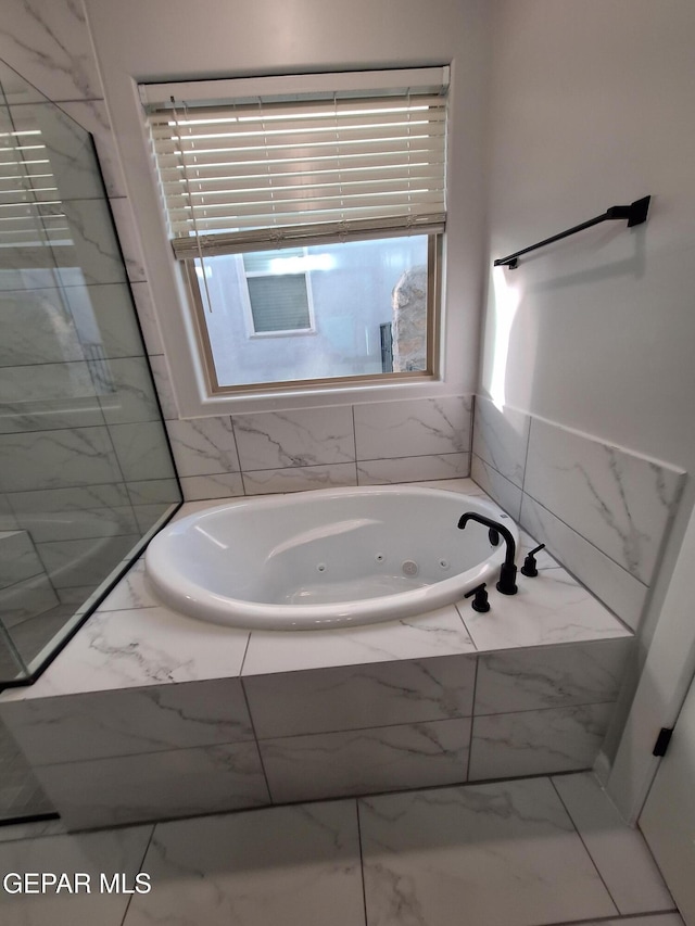 bathroom featuring tiled tub