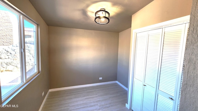 unfurnished bedroom featuring hardwood / wood-style flooring and a closet