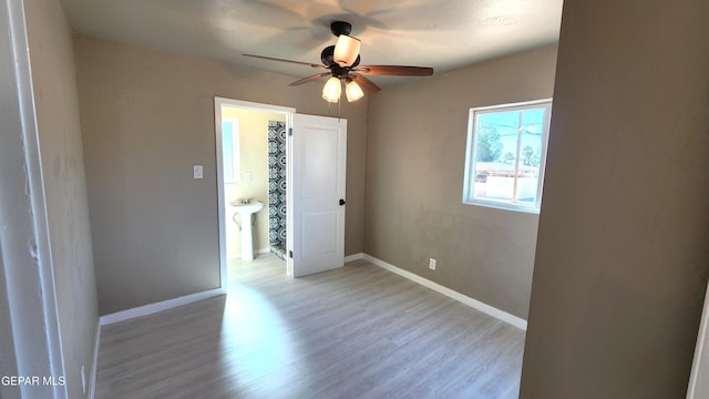 empty room with ceiling fan, sink, and light wood-type flooring