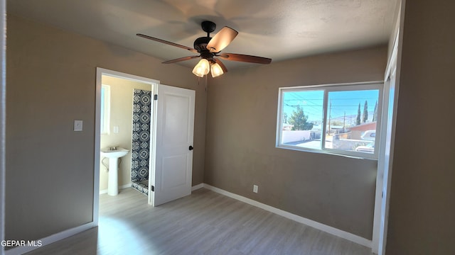 unfurnished bedroom with ceiling fan, sink, and light hardwood / wood-style flooring