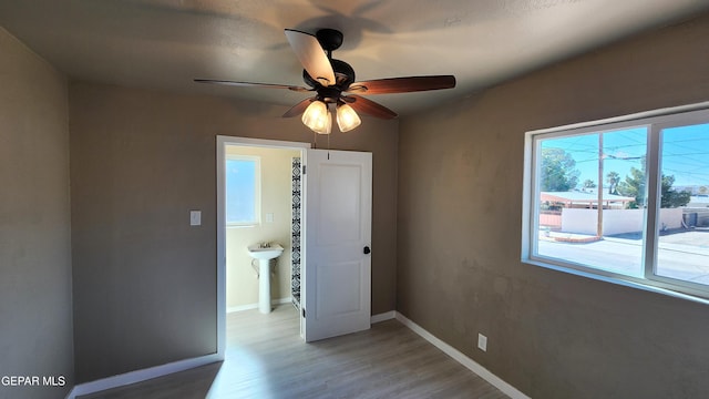 empty room with hardwood / wood-style floors and ceiling fan