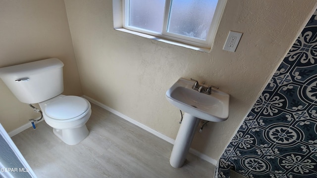 bathroom with wood-type flooring and toilet