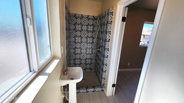 bathroom featuring hardwood / wood-style flooring and tiled shower