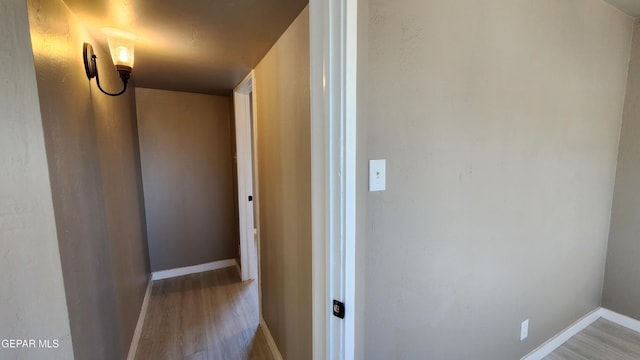 corridor with hardwood / wood-style flooring