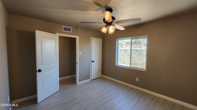 unfurnished bedroom with ceiling fan and light hardwood / wood-style flooring