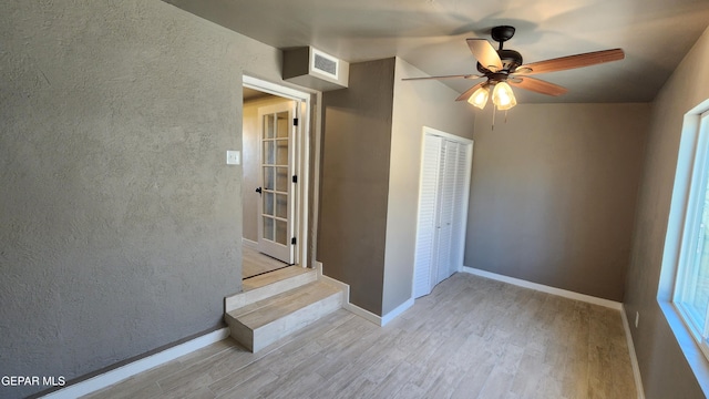 unfurnished bedroom featuring ceiling fan, a closet, and light hardwood / wood-style flooring