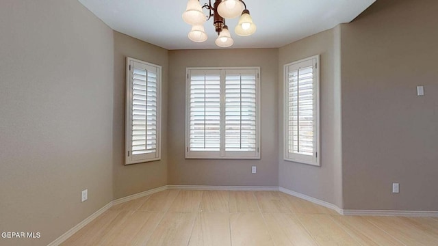 unfurnished room featuring an inviting chandelier