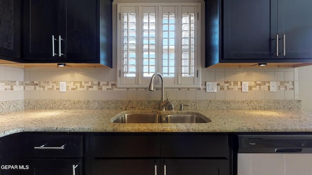 kitchen with tasteful backsplash, light stone countertops, sink, and stainless steel dishwasher