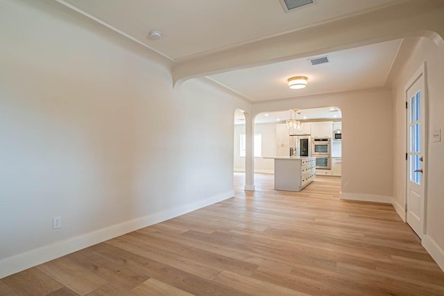 interior space featuring a notable chandelier and light wood-type flooring