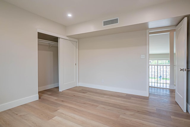 unfurnished bedroom featuring a closet and light hardwood / wood-style flooring