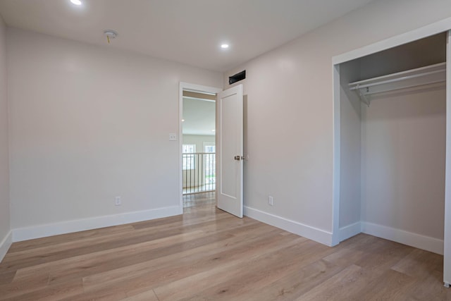 unfurnished bedroom featuring a closet and light hardwood / wood-style flooring
