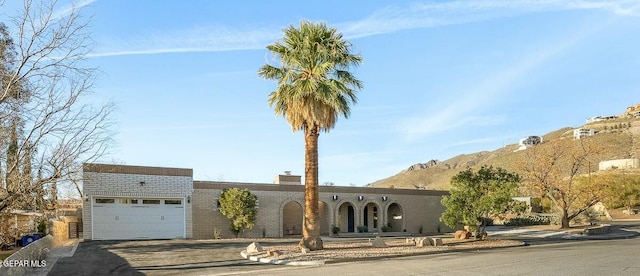 view of front facade featuring a mountain view and a garage