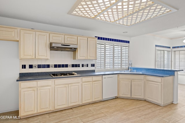 kitchen with sink, white appliances, cream cabinetry, and backsplash