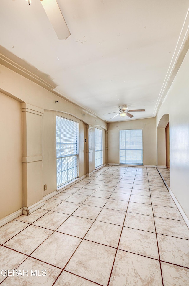 tiled spare room featuring ceiling fan