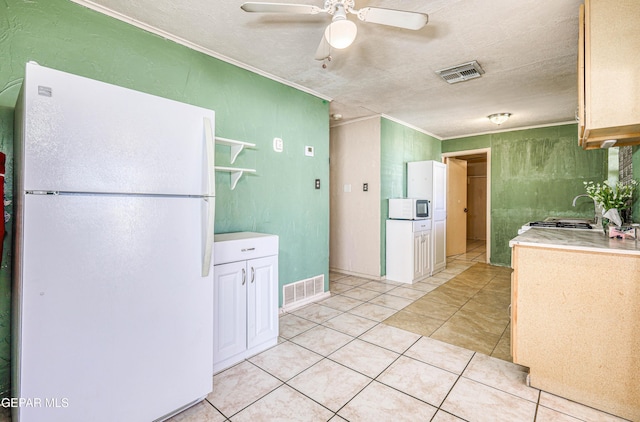 kitchen with light tile patterned floors, white appliances, ceiling fan, ornamental molding, and a textured ceiling