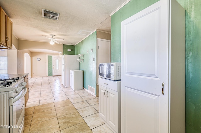 kitchen with crown molding, white appliances, a textured ceiling, light tile patterned floors, and ceiling fan