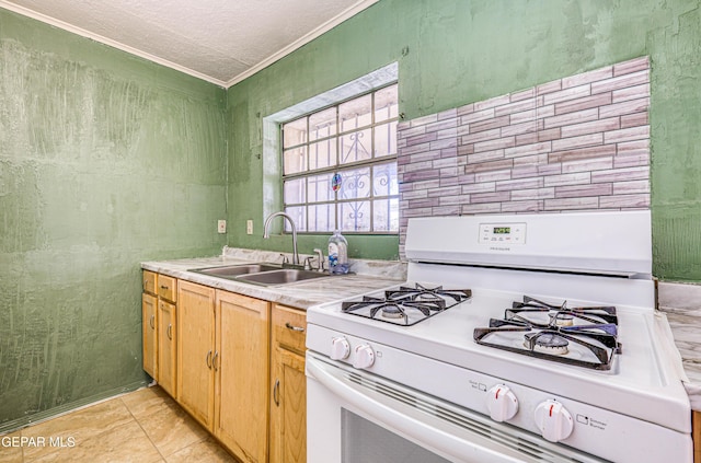 kitchen with sink, crown molding, a textured ceiling, light tile patterned floors, and white range with gas cooktop