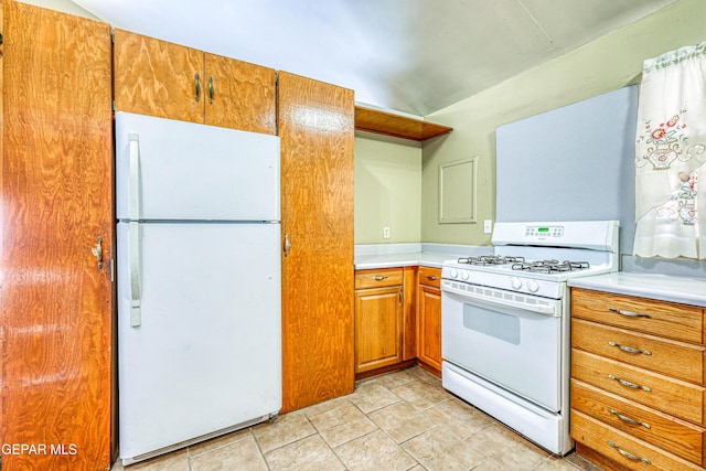 kitchen featuring light tile patterned flooring and white appliances