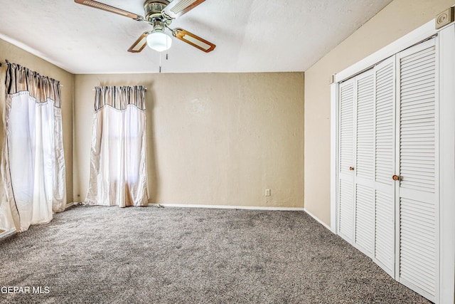 unfurnished bedroom featuring ceiling fan, carpet floors, a closet, and a textured ceiling