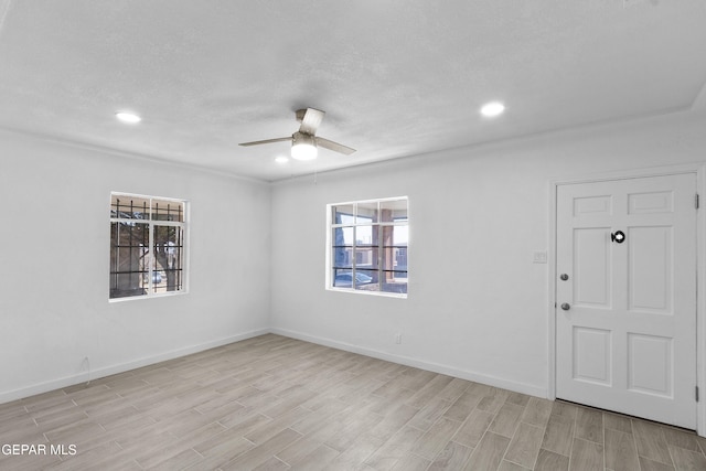 unfurnished room with a textured ceiling, light hardwood / wood-style flooring, and ceiling fan