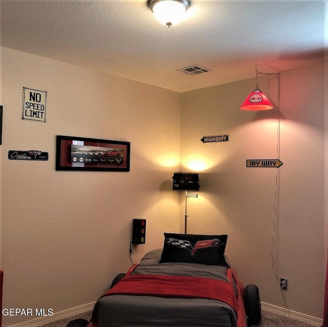 carpeted bedroom with baseboards, visible vents, and a textured ceiling