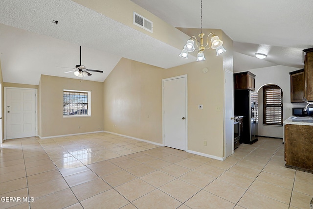 kitchen featuring lofted ceiling, ceiling fan with notable chandelier, and light tile patterned flooring