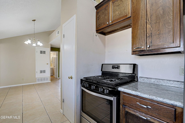 kitchen with light tile patterned flooring, lofted ceiling, gas stove, decorative light fixtures, and a notable chandelier