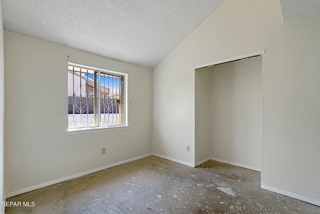 unfurnished bedroom with lofted ceiling and a textured ceiling