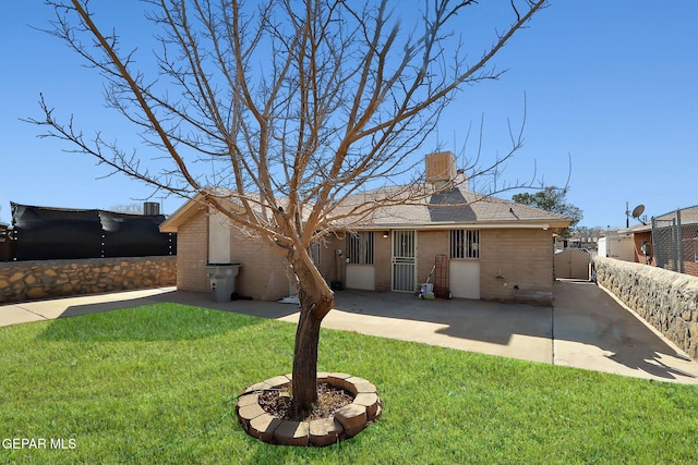 rear view of house featuring a yard and a patio