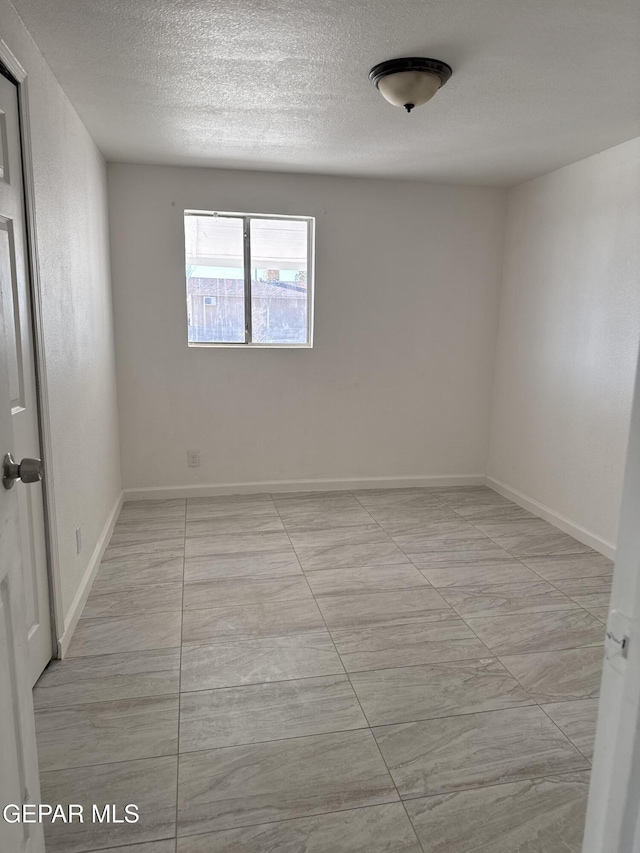 unfurnished room featuring a textured ceiling