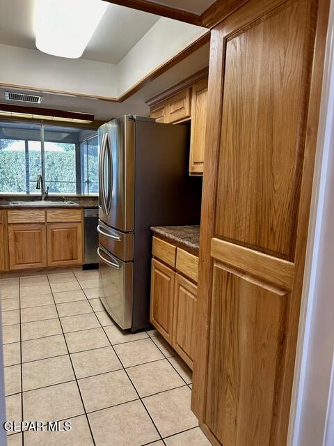 kitchen with stainless steel appliances, sink, and light tile patterned floors