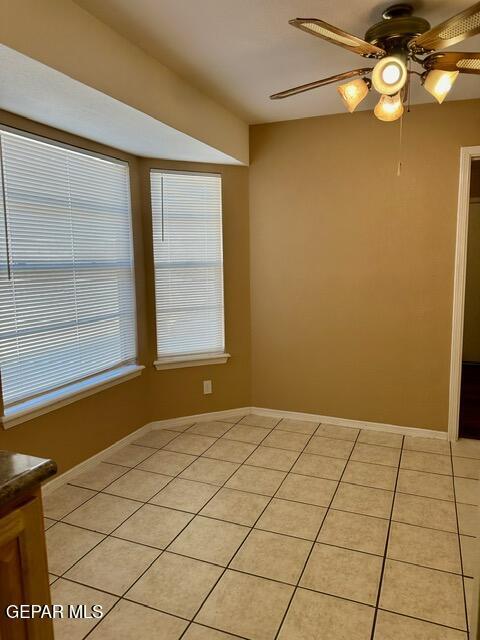 empty room with light tile patterned floors and ceiling fan