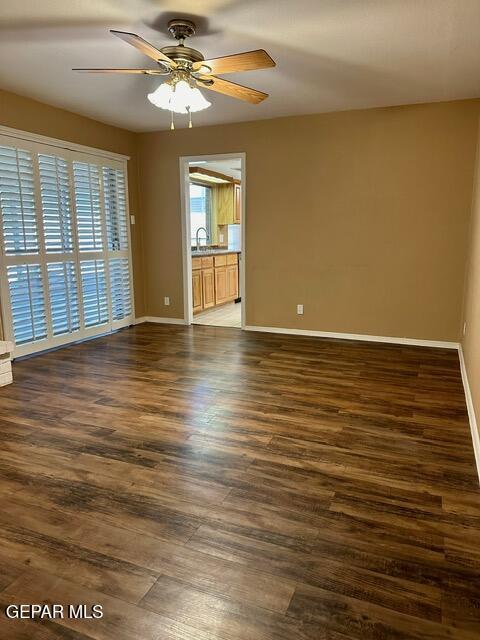 empty room featuring ceiling fan, dark hardwood / wood-style floors, and sink