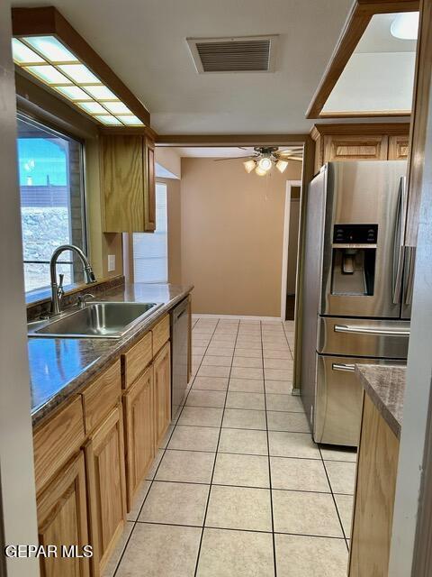 kitchen featuring sink, light tile patterned floors, ceiling fan, and appliances with stainless steel finishes