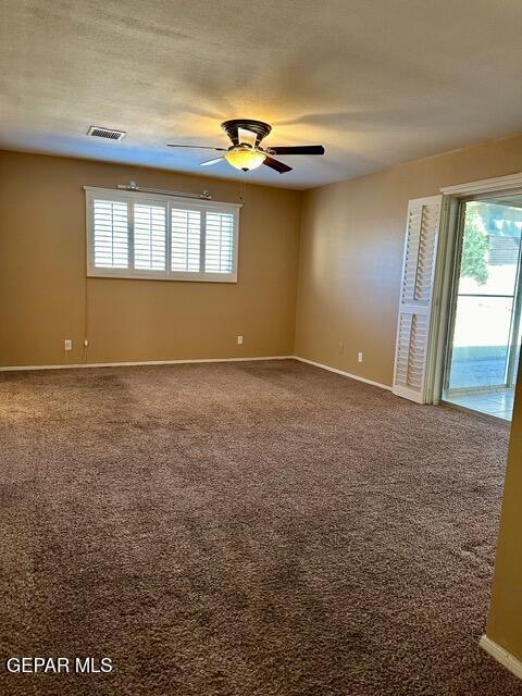 carpeted empty room featuring a textured ceiling and ceiling fan