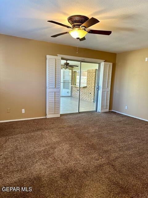 empty room with ceiling fan, carpet flooring, and a textured ceiling