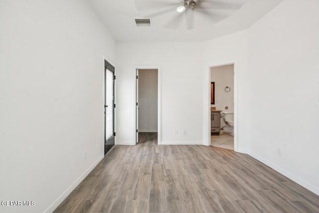 unfurnished bedroom with connected bathroom, light hardwood / wood-style flooring, a spacious closet, ceiling fan, and a closet