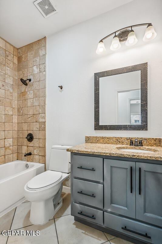 full bathroom with tile patterned flooring, vanity, tiled shower / bath combo, and toilet