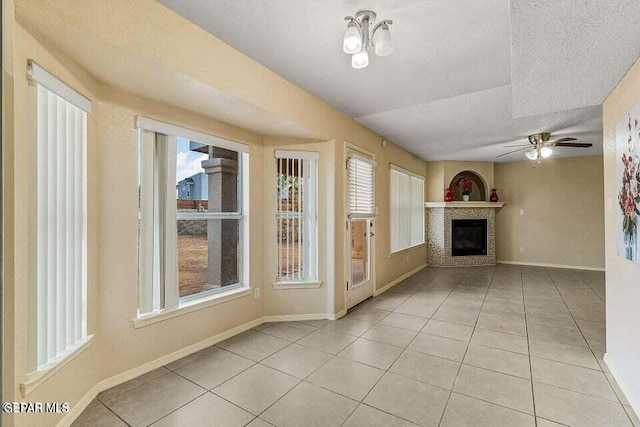 unfurnished living room with light tile patterned floors, a textured ceiling, and ceiling fan