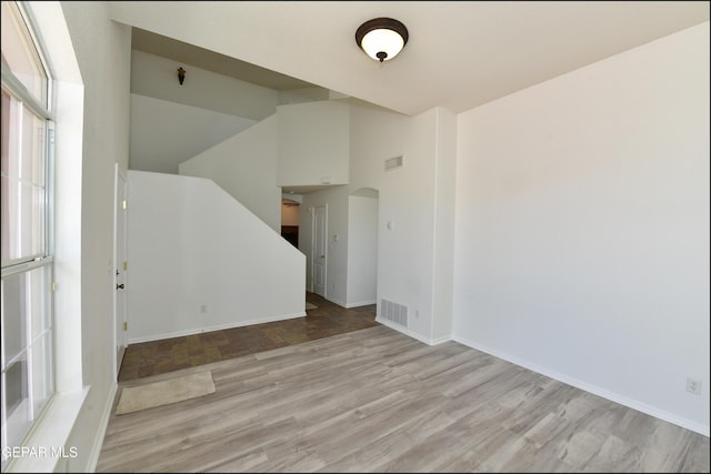 spare room with lofted ceiling and light hardwood / wood-style floors