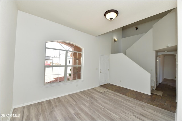 interior space featuring a towering ceiling and light hardwood / wood-style flooring