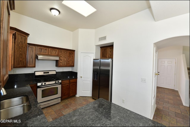 kitchen with stainless steel appliances, vaulted ceiling, sink, and kitchen peninsula