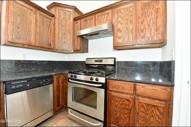 kitchen with dark stone countertops and appliances with stainless steel finishes