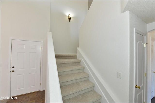 stairs with a textured ceiling