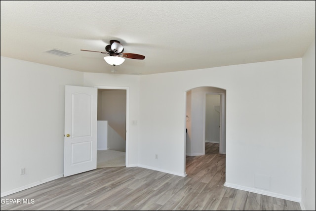 spare room featuring ceiling fan, a textured ceiling, and light wood-type flooring