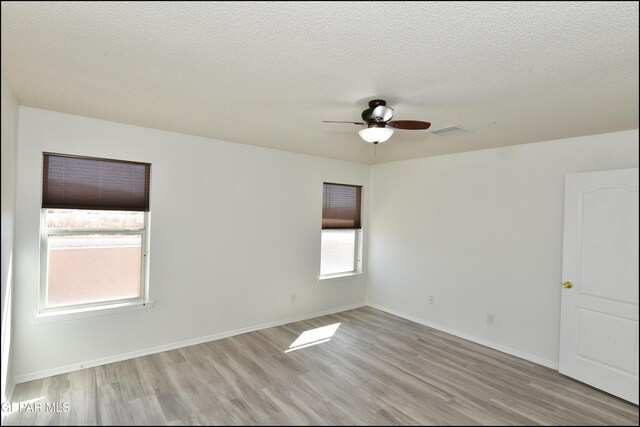 unfurnished room featuring ceiling fan, a textured ceiling, and light wood-type flooring